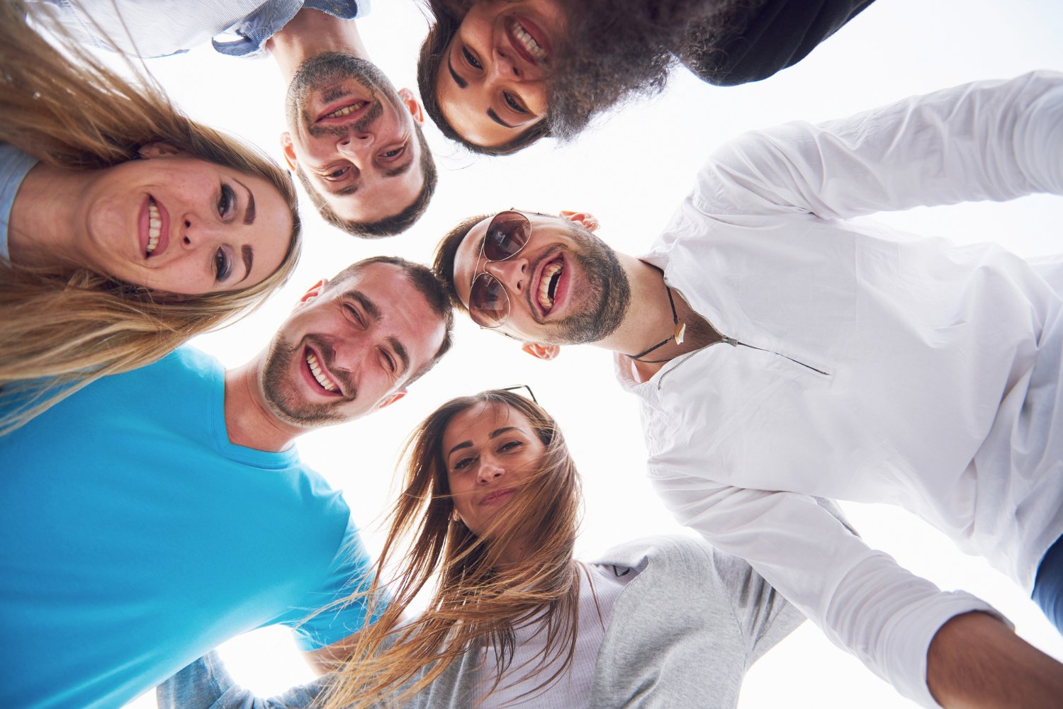 A diverse group of friends smiling together in a circle