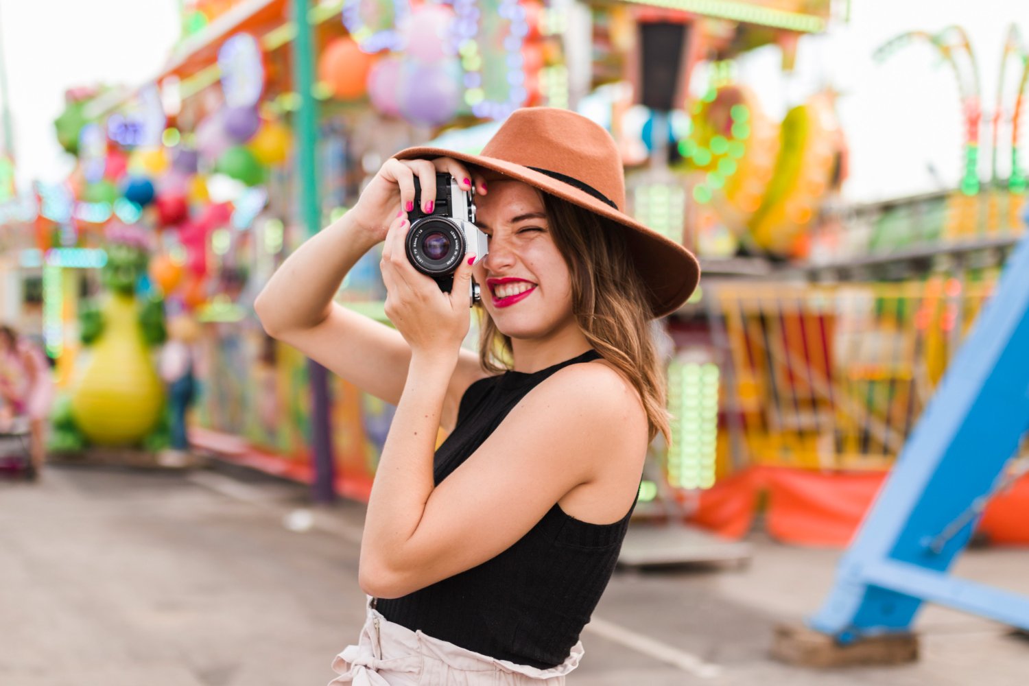 A woman taking a photo while enjoying a day at a fair