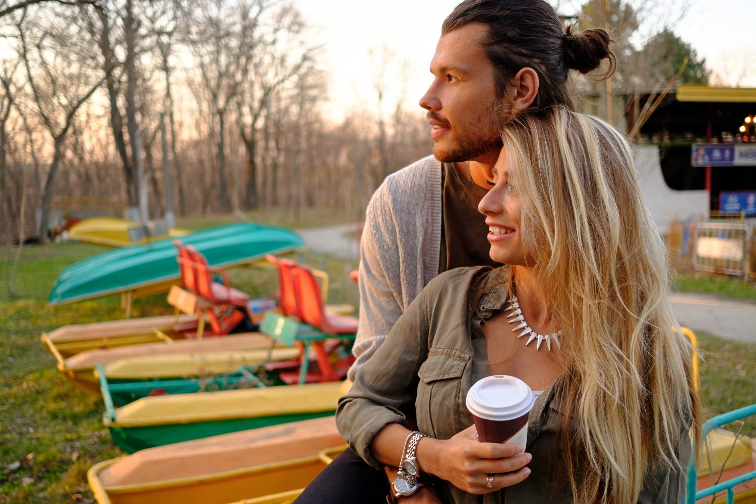 A couple enjoying a relaxed moment together beside colorful boats